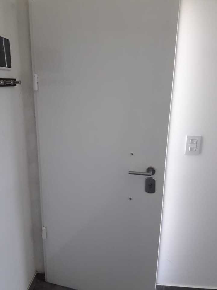 Blindaje de puerta interior blanca lisa con herrajes modernos de seguridad.