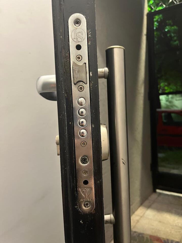 Detalle de pernos de acero macizo en cerradura multianclaje de puerta reforzada