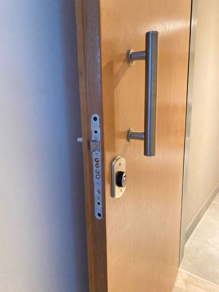 Detalle de cerradura multianclaje de máxima seguridad en puerta blindada de madera.