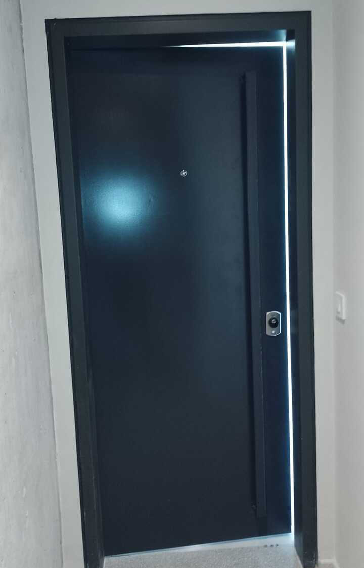 Puerta de seguridad color grafito entreabierta mostrando el gran grosor del blindaje interno