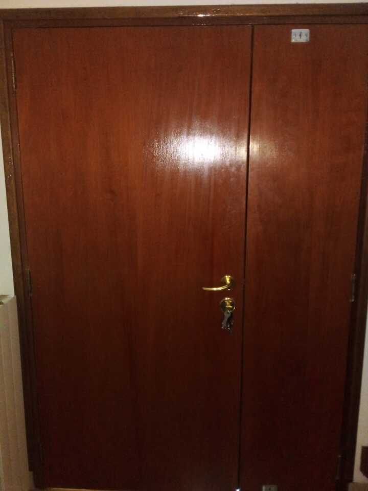 Puerta acorazada doble de madera lisa instalada en acceso interior de vivienda