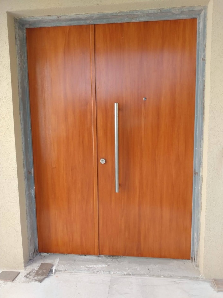 Puerta acorazada doble de madera moderna con gran barral de acero inoxidable y cerradura de seguridad