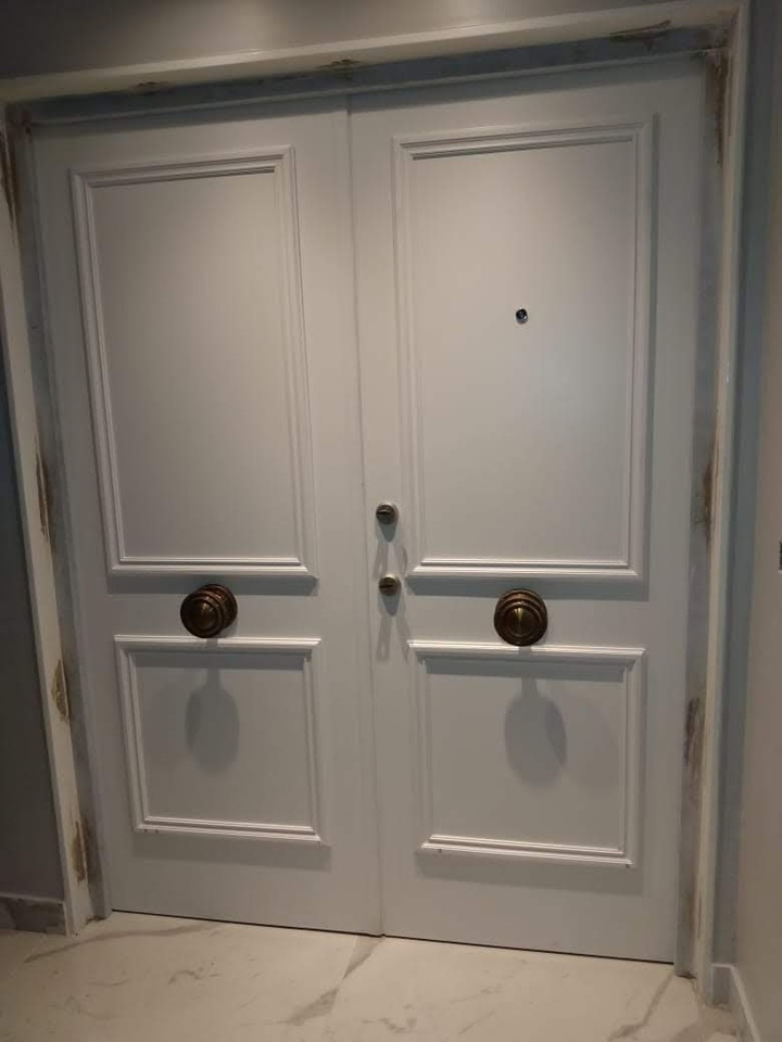 Instalación de puerta blindada doble blanca con molduras clásicas y cerradura multianclaje de seguridad
