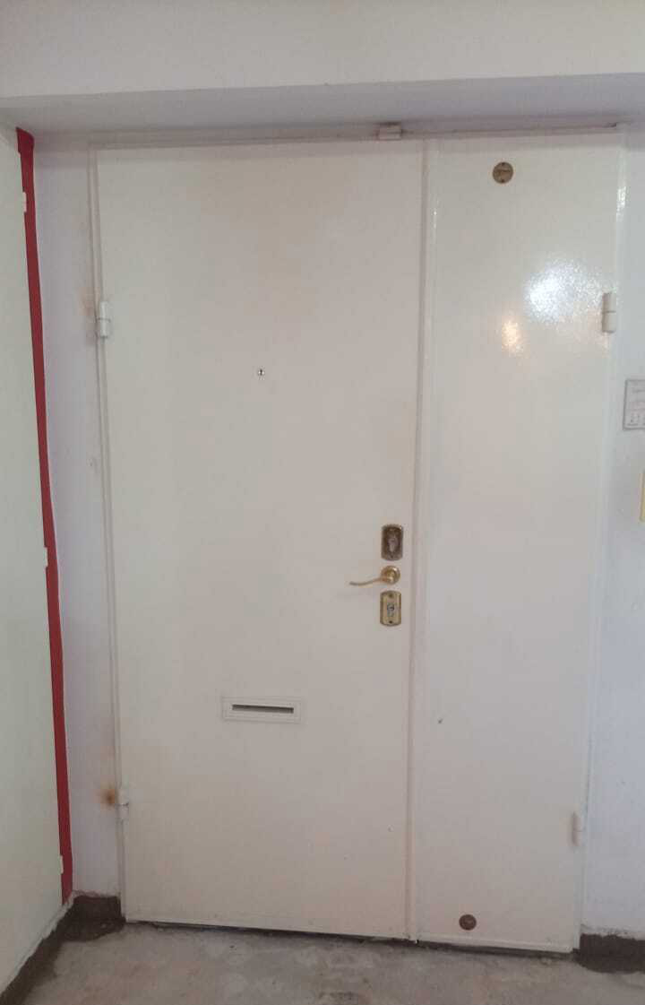 Puerta de seguridad doble hoja asimétrica color blanco con buzón instalada en interior